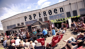 People sitting around on deckchairs eating and drinking