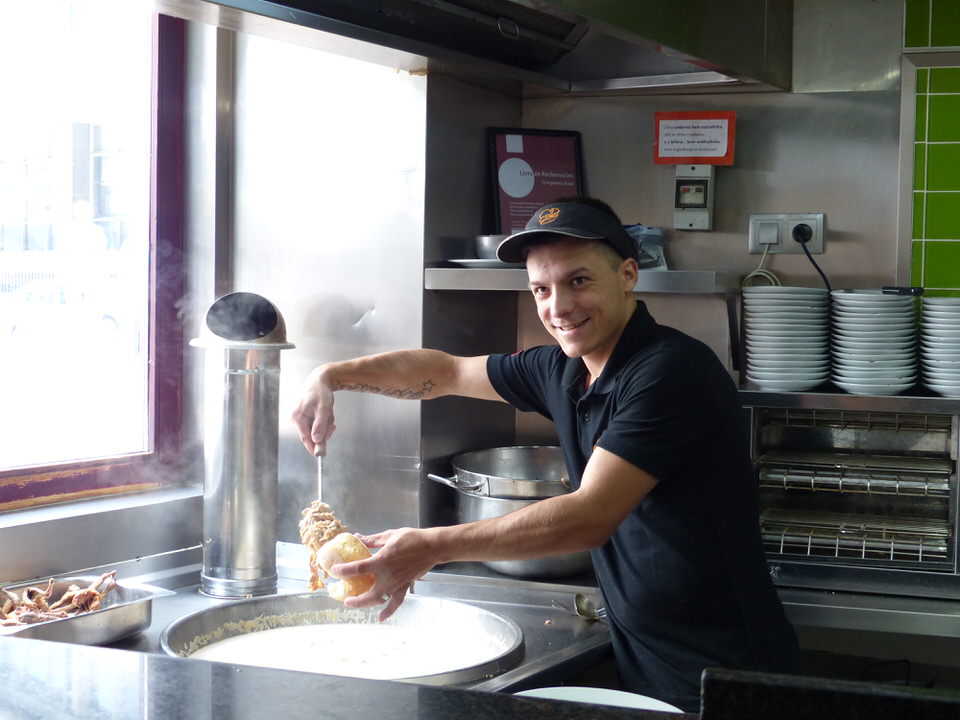 A man making a bifana sandwich