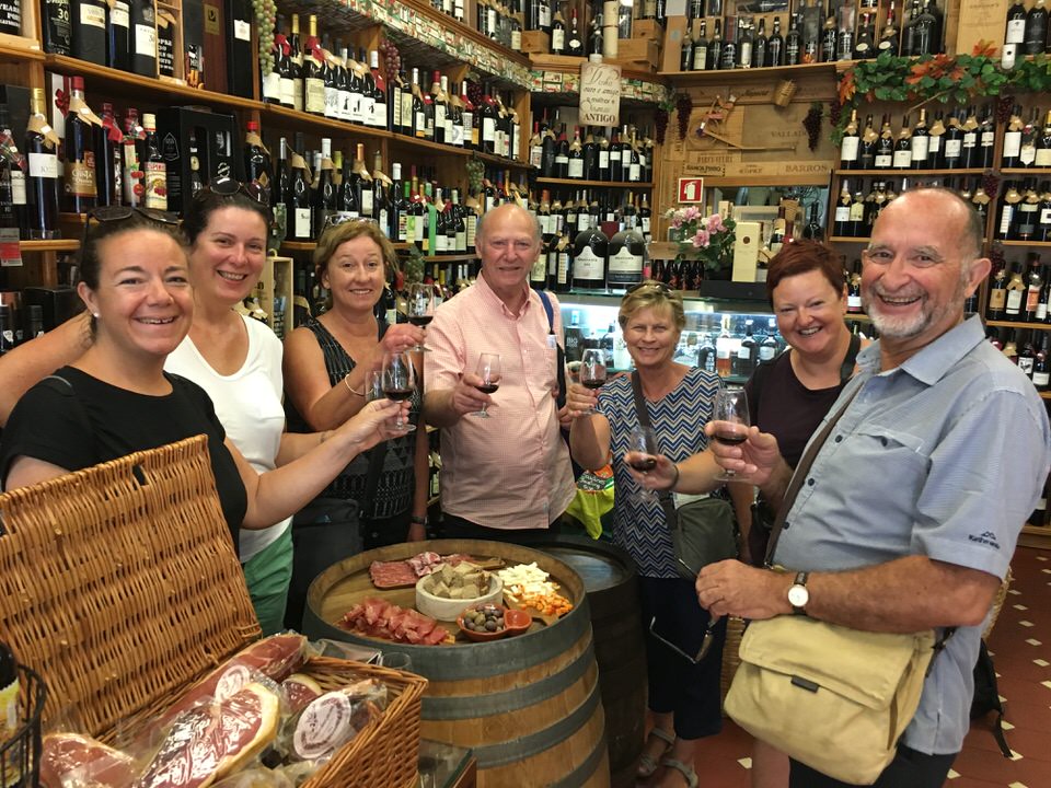 a group of people in a grocery store with port wine saying cheers.