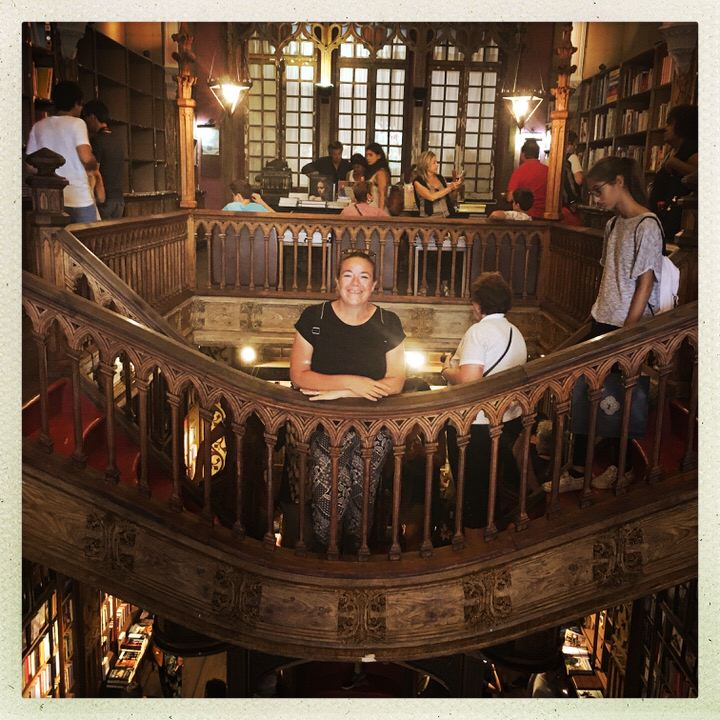 Claire on a stair bridge in a bookstore