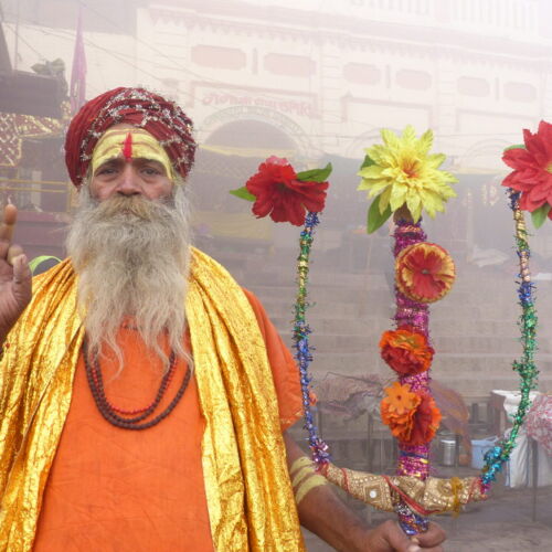 Holy man Varanasi Photos of India, Holy man Varanasi, stood with red and yellow flowers.