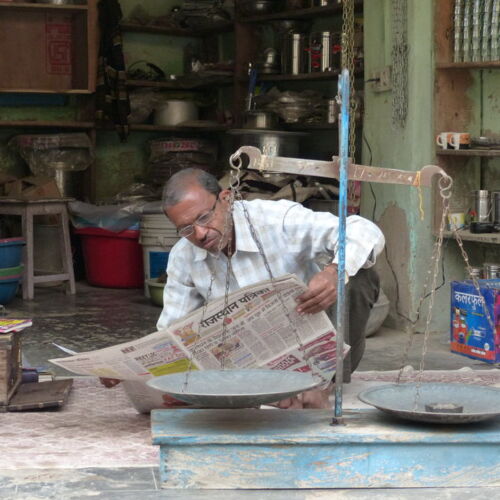 A quiet moment in the busy Nawalgarh Bazaar Photos of India, man sat reading the paper in his shop at Nawalgarh Bazaar