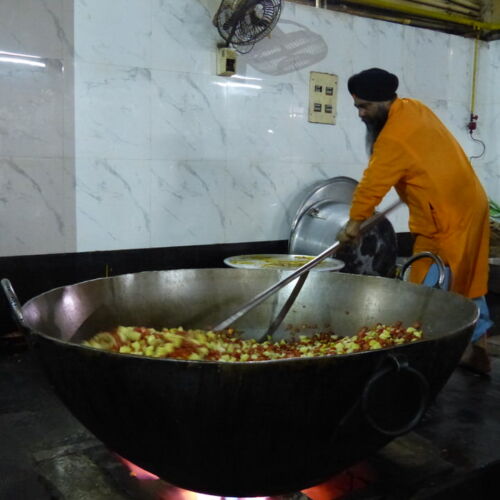 Soup kitchen in Bangla Sahib Temple India Photos of India, Bangla Sahib Soup kitchen, man stirring a huge pot of food