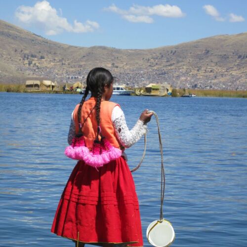 Photos of Peru, A young girl gathering water on the shore of lake Titicaca.
