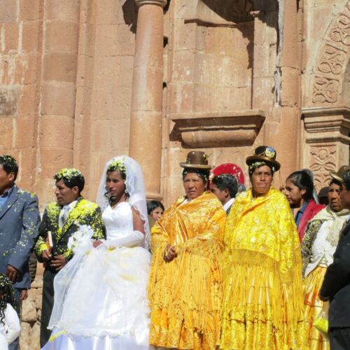 Photos of Peru, A wedding shot including the bride and groom in modern dress and the bridesmaids in more traditional yellow dresses and bowler hats.